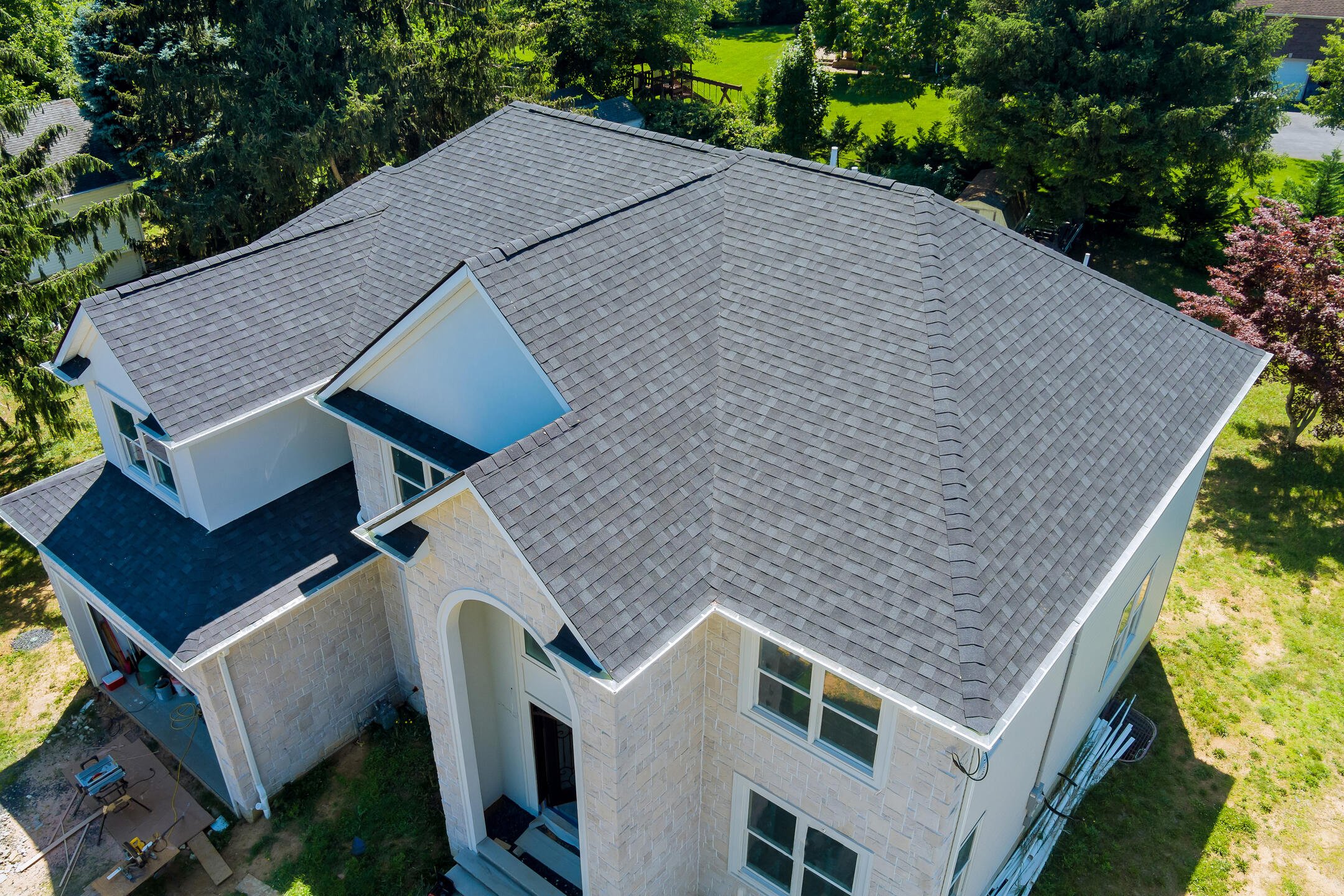 how long does a roof last-aerial view of a white sided house with new gray shingle roof