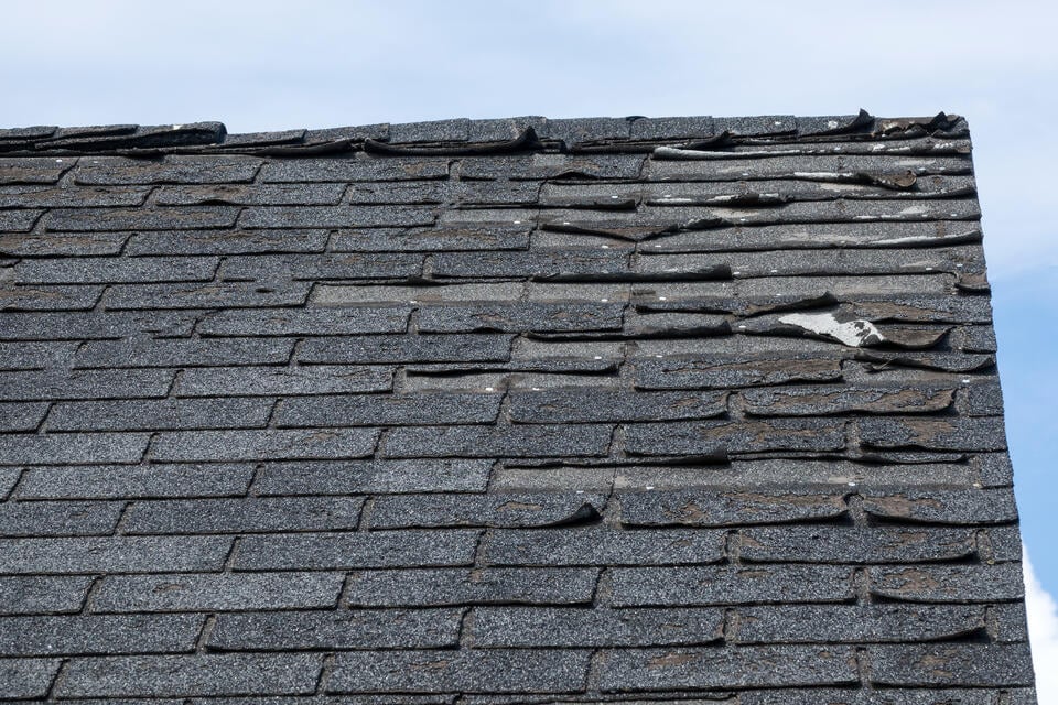 how long does a roof last-close up of old shingles on a roof that need to be replaced
