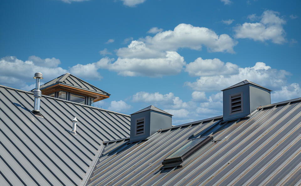 metal roof vs shingles-gray standing seam metal roof on a house