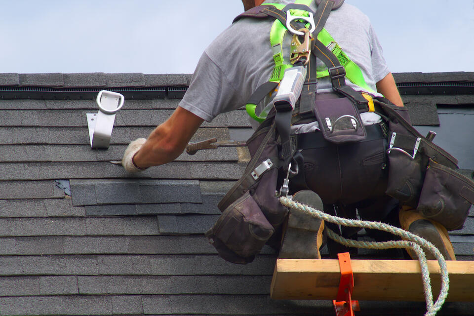roof leak repair-roofer repairing a section of a shingle roof