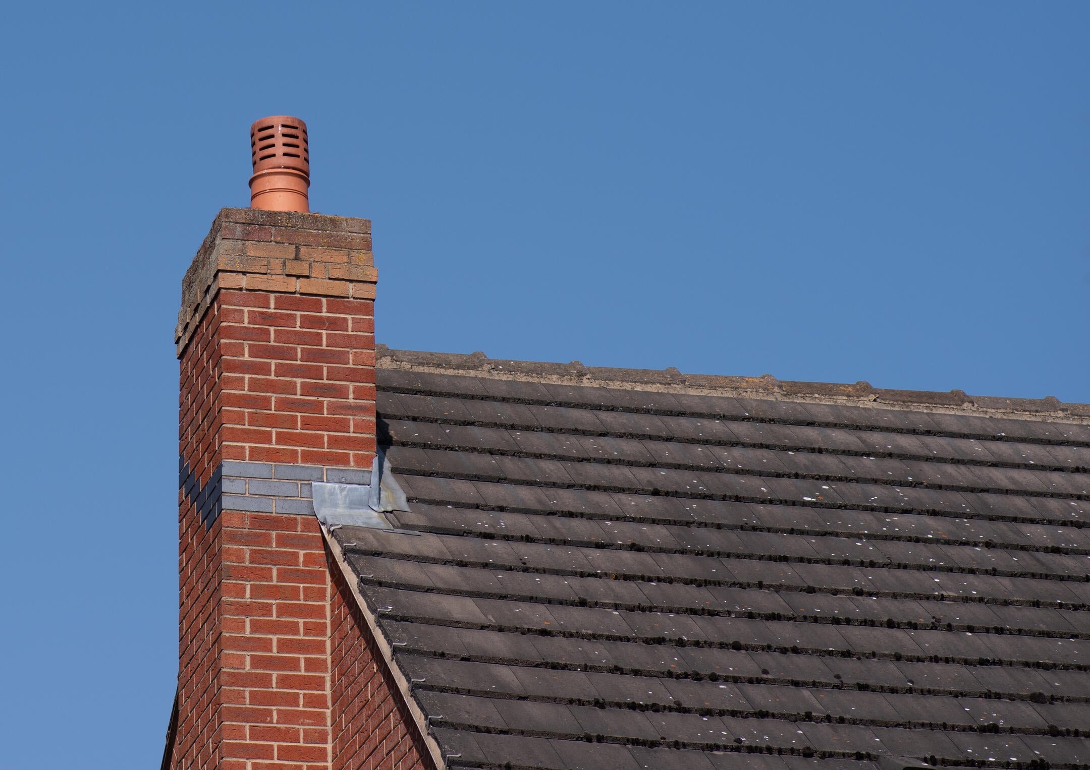 chimney flashing repair-close up of metal chimney flashing on roof