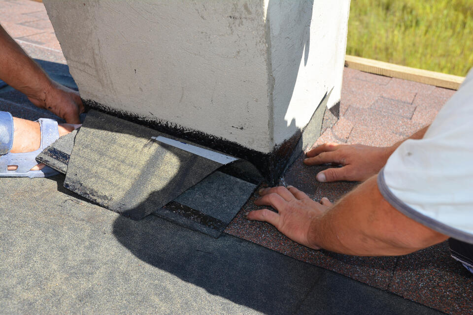 chimney flashing repair-close up of techs repairing roofing around chimney