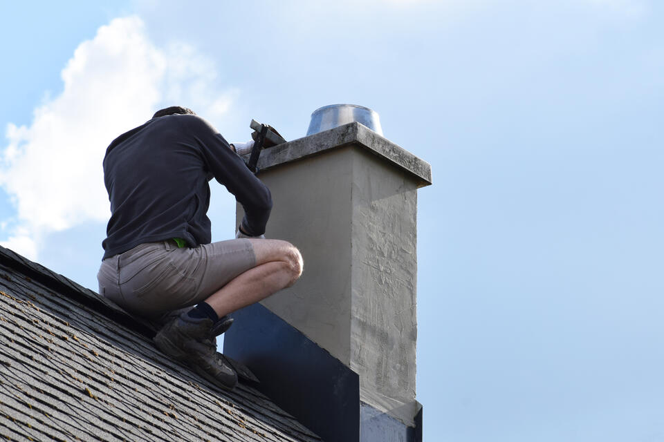 chimney flashing repair-man repairing section of chimney flashing