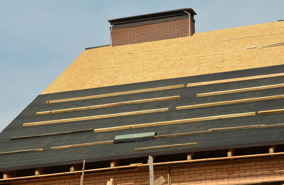 roofing underlayment-roof underlayment being installed on roof decking