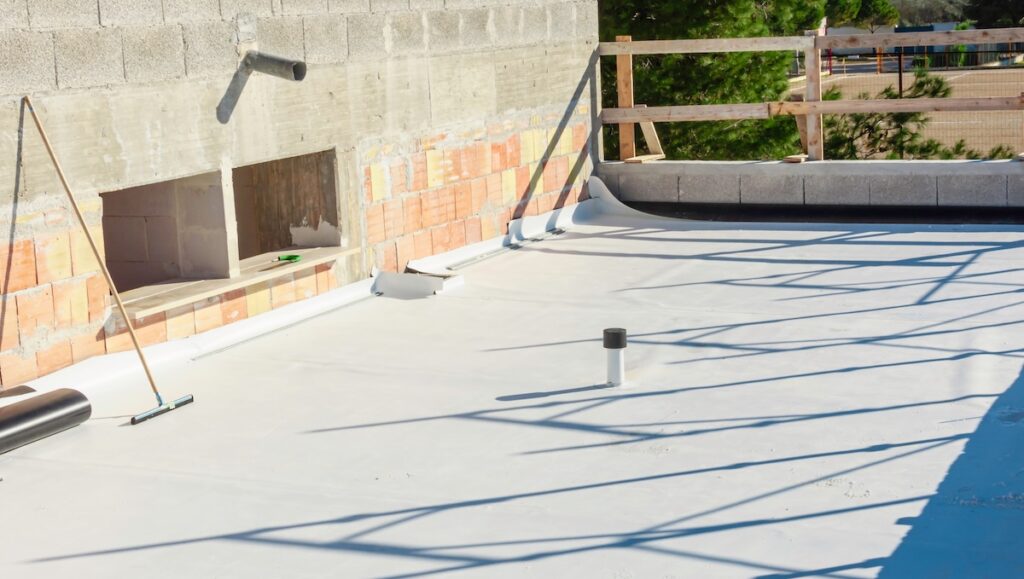 Worker applies pvc membrane roller on roof very carefully. Correct welding with hand-welder, corner.