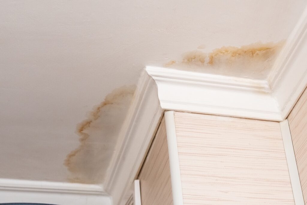 Neighbors have a water leak, water-damaged ceiling, close-up of a stain on the ceiling. how to find a roof leak