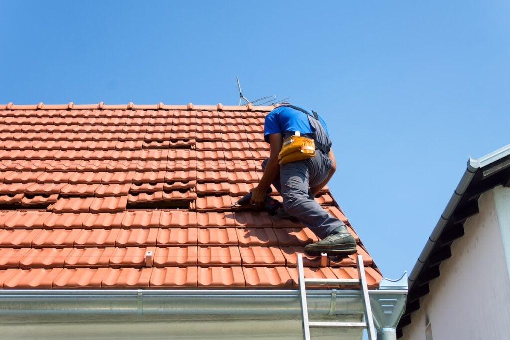 Worker on the roof tile roofing