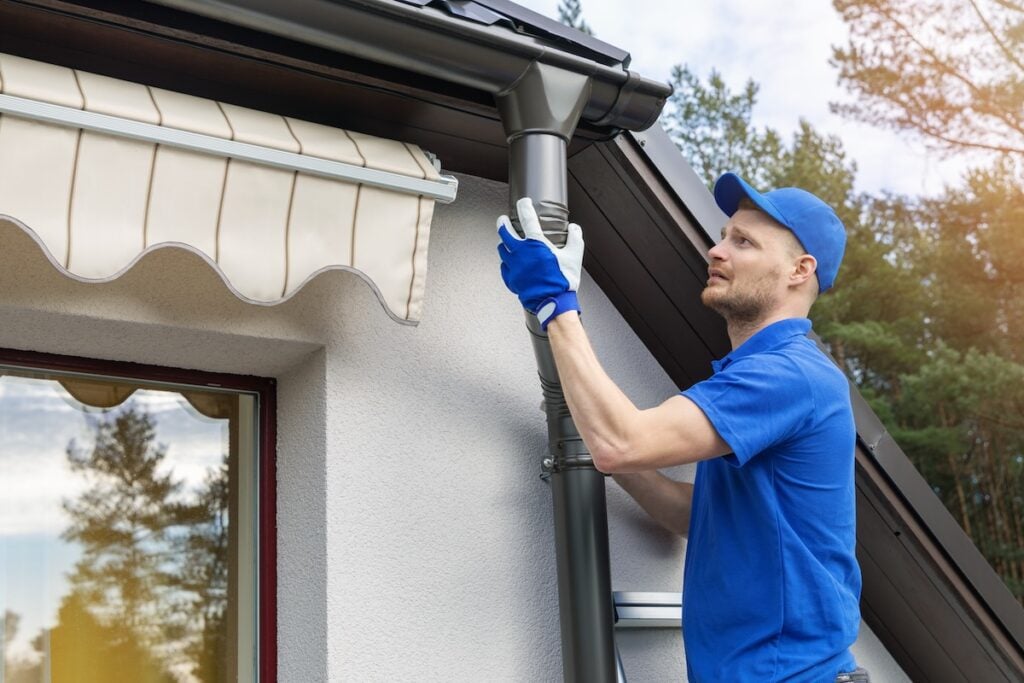 worker installing house roof rain gutter system gutter replacement cost