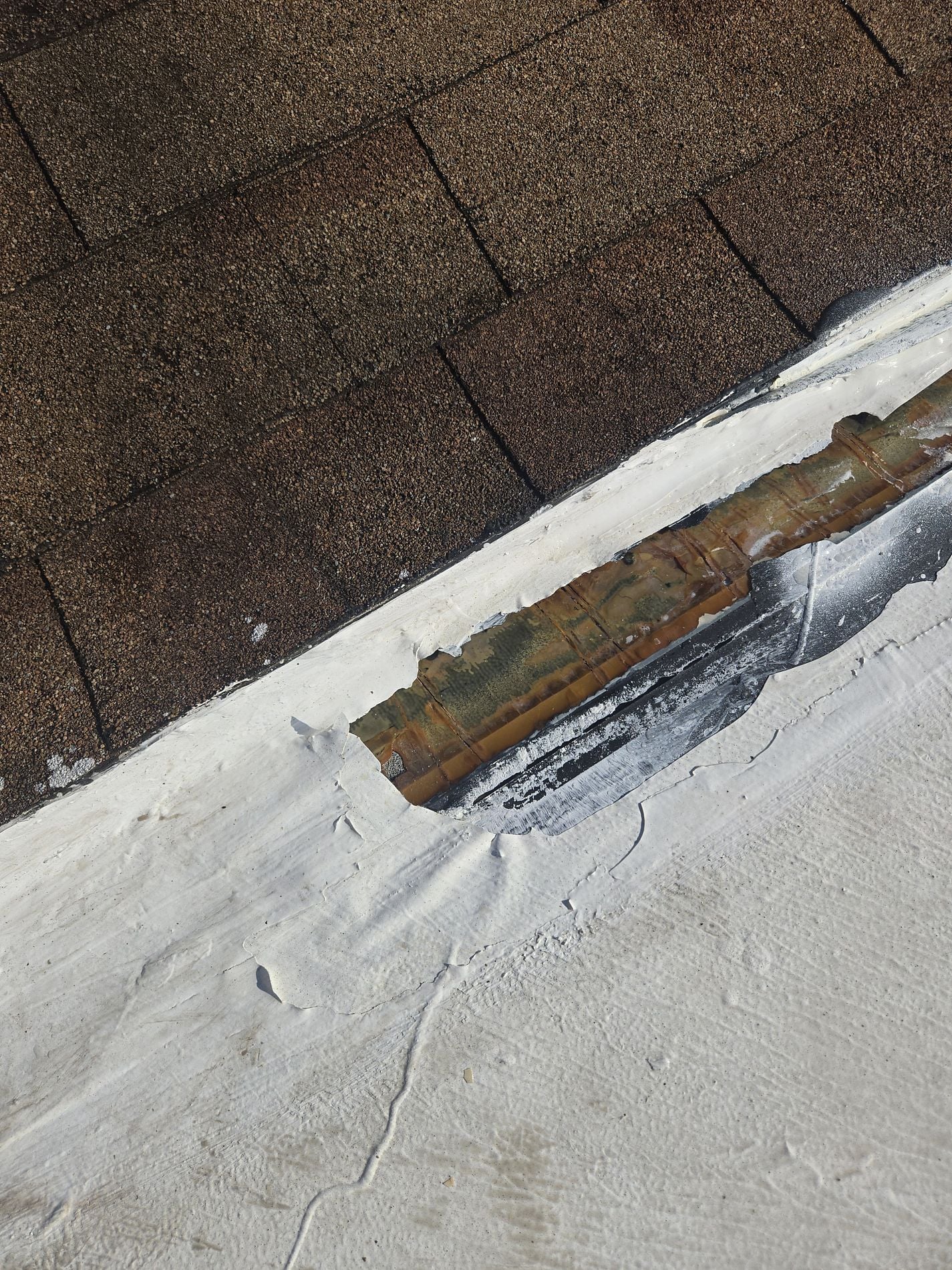 Damaged flat roof membrane with repeated patching and exposed roof materials