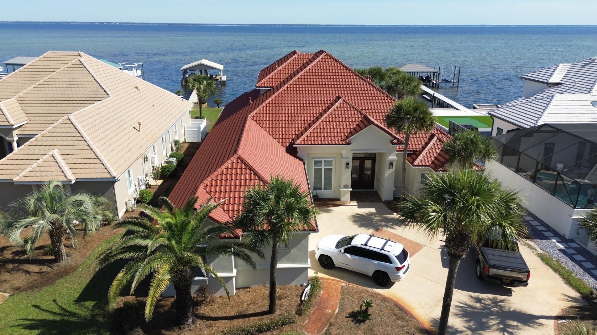 Aerial view of a red DECRA stone-coated steel roof on a waterfront home in Panama City Beach, Florida