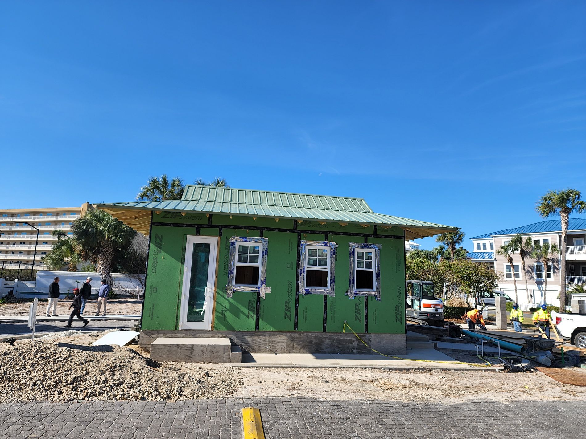 Green exposed-fastener metal roof installed on a new construction building in Destin, Florida