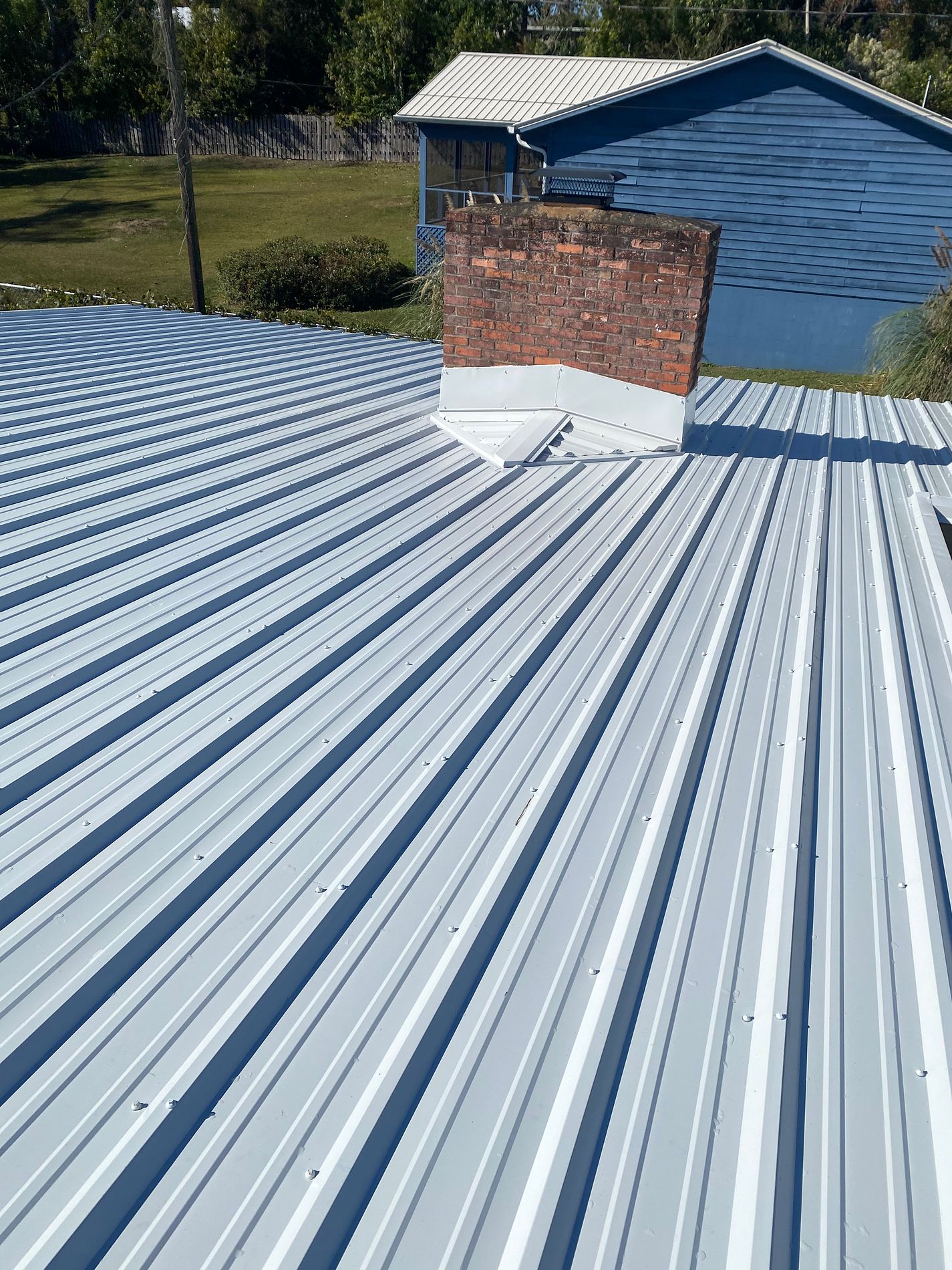 White exposed-fastener metal roof installed on a property in Marianna, Florida