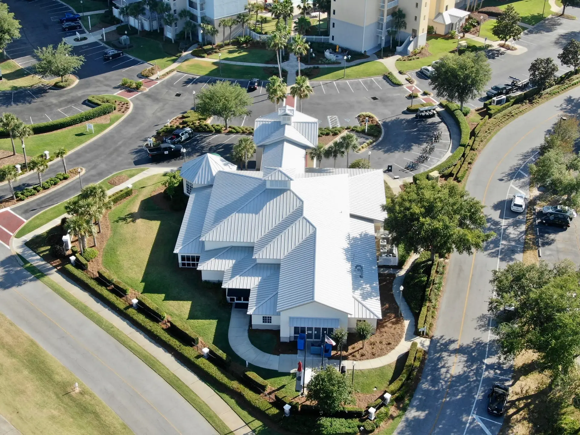 Aerial view of a gray asphalt shingle roof on a large equestrian estate building in Florida