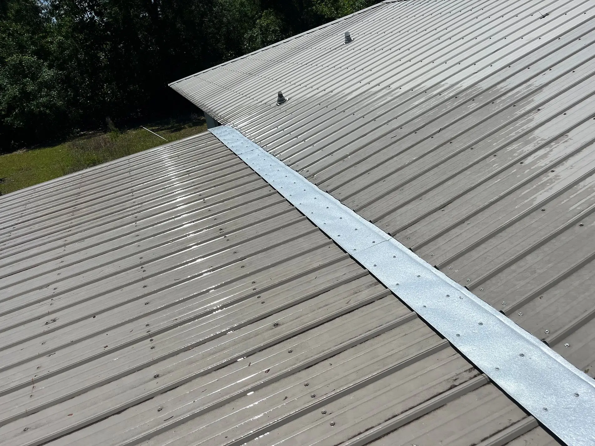 Metal roof transition flashing installed between two roof sections