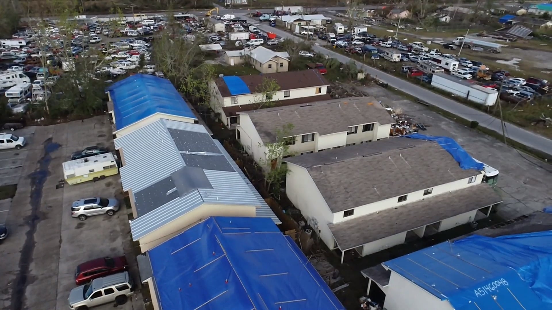 Aerial view of commercial buildings protected with emergency roof tarps after storm damage