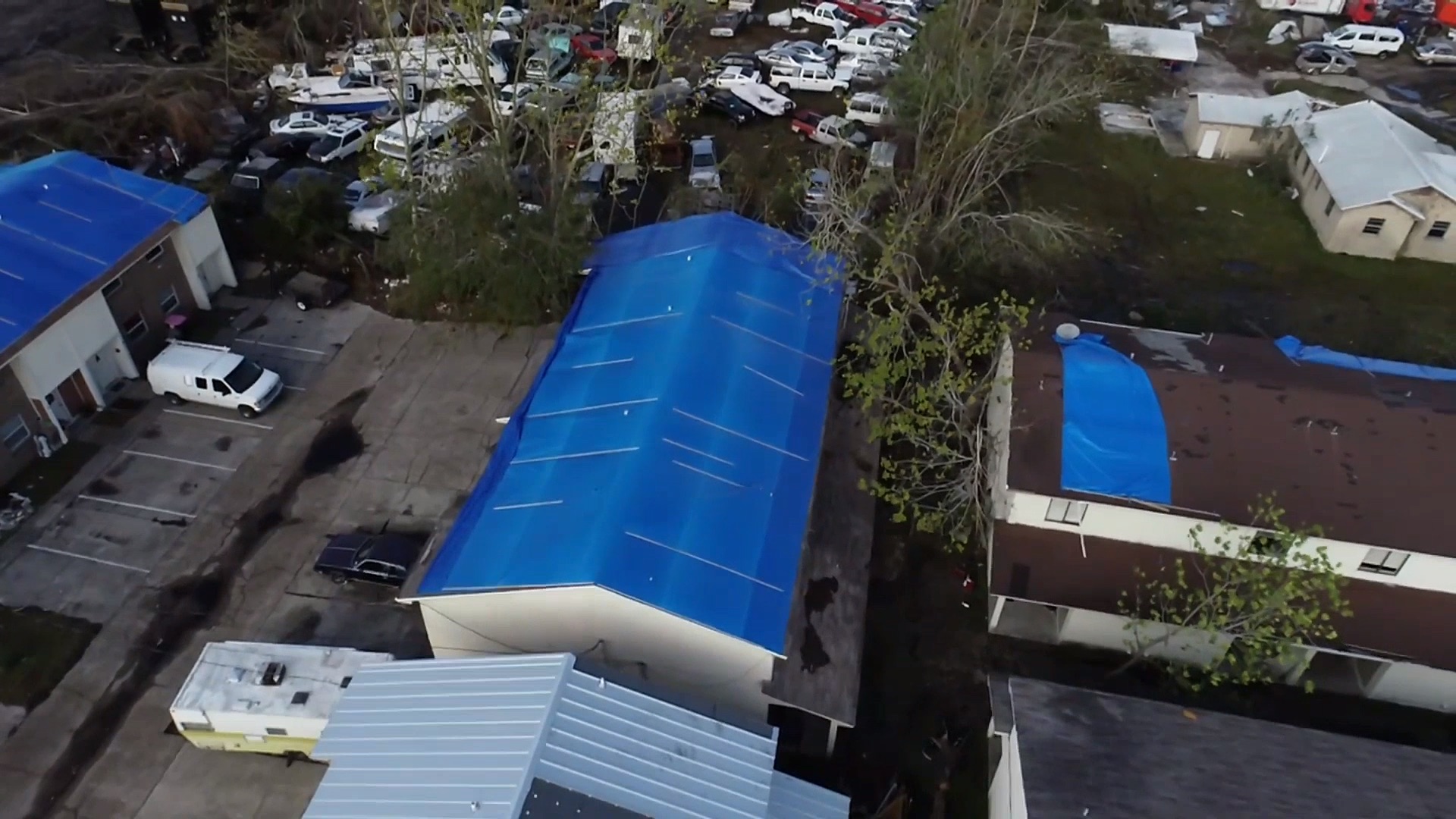 Aerial view of a blue emergency roof tarp installed on a commercial building in Ocala, Florida