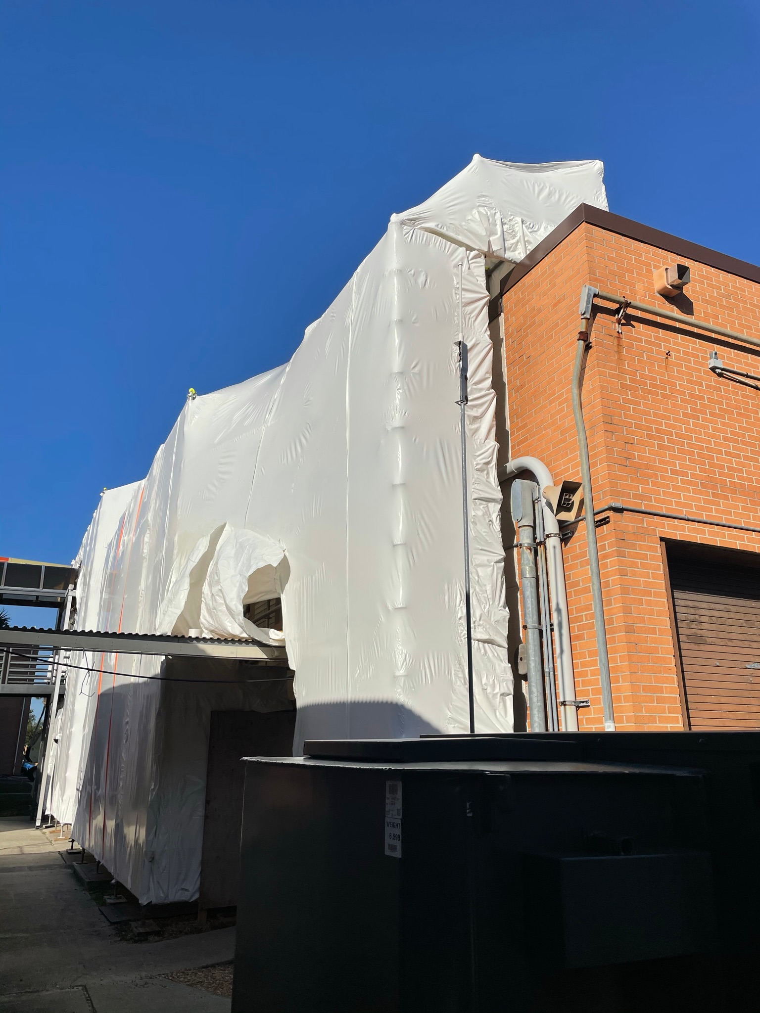 Commercial building protected with emergency tarping after roof leak or storm damage