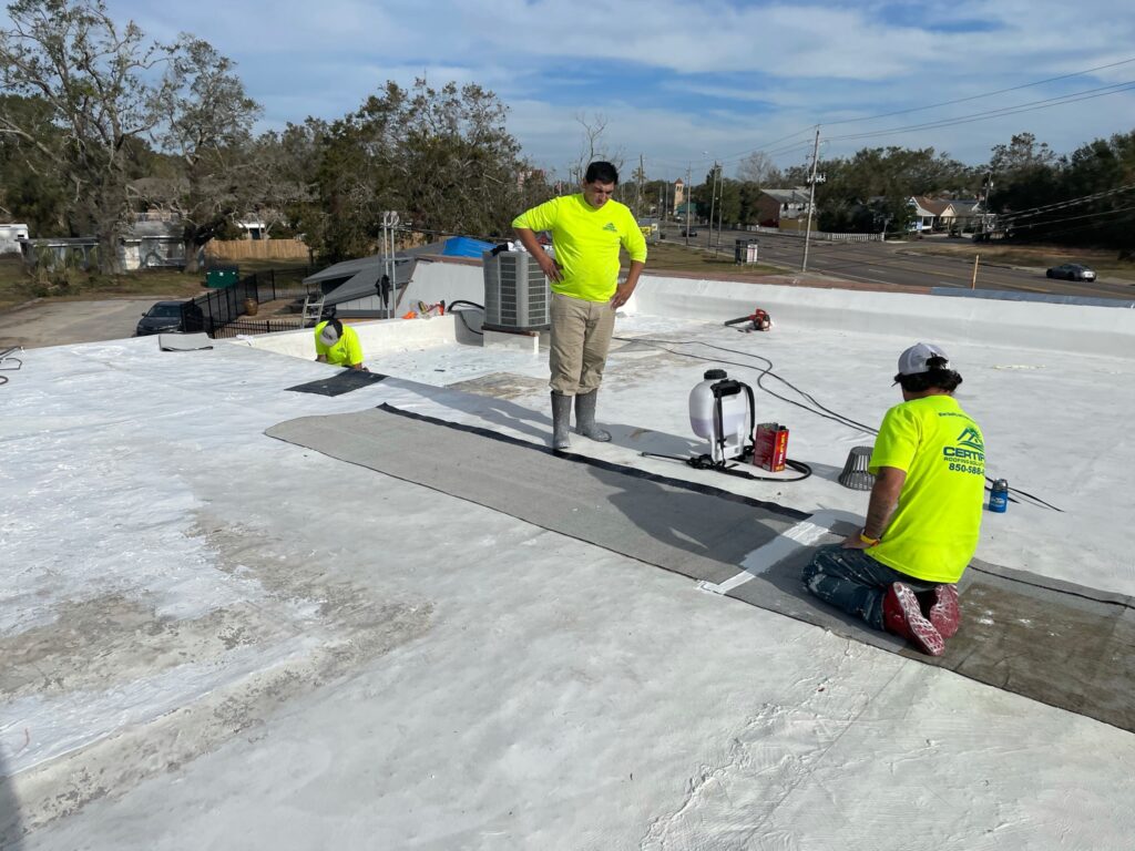 Roofing contractors repairing a damaged commercial flat roof in Florida