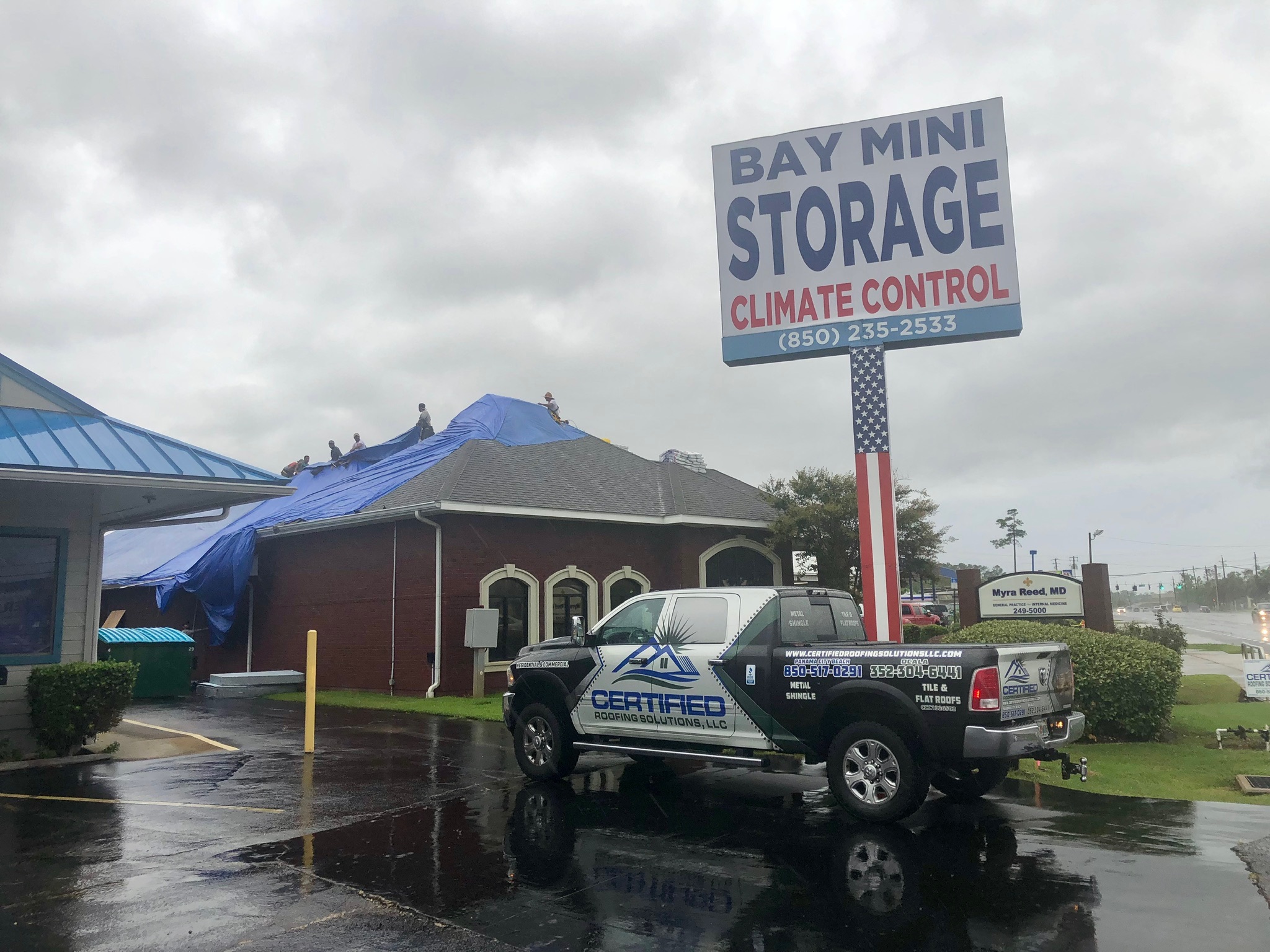 Commercial emergency roof tarp installation at Bay Mini Storage in Lynn Haven, Florida