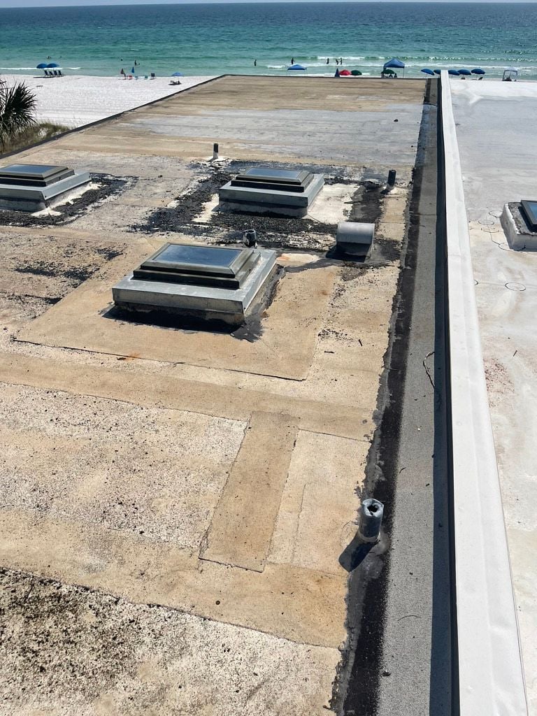 Damaged commercial flat roof with deteriorated membrane and leaking skylight flashing