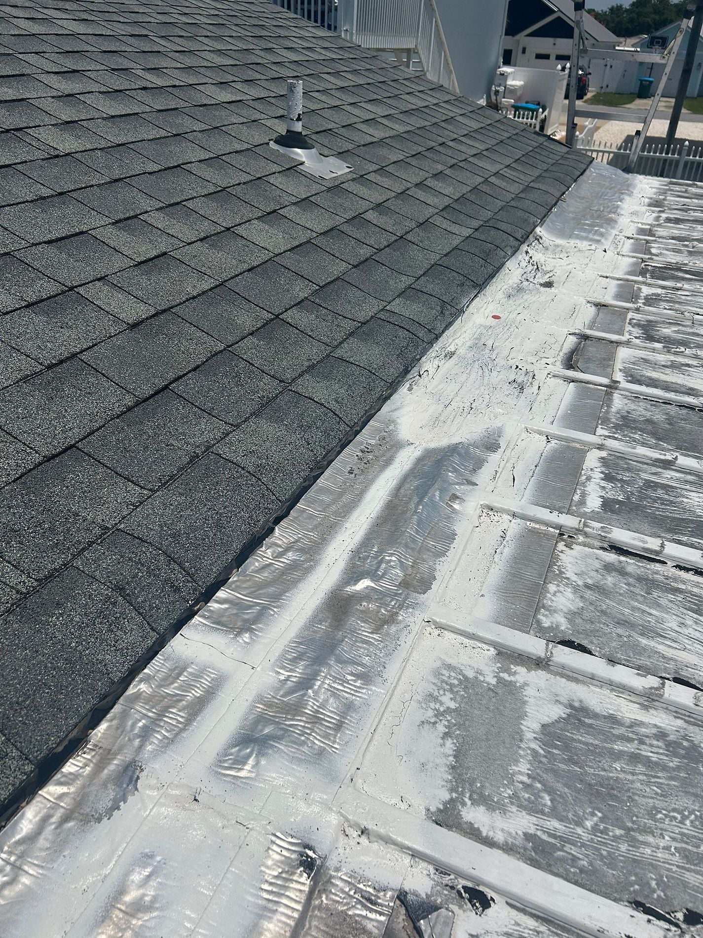 Damaged roof transition flashing between an asphalt shingle roof and a low-slope roof