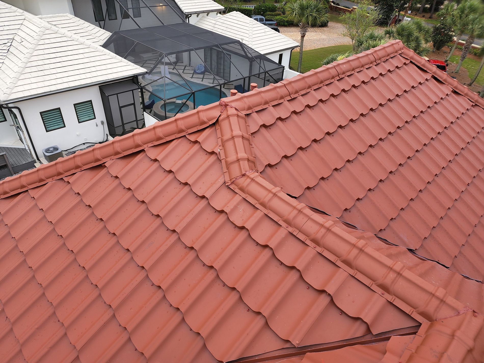 Red stone-coated steel roofing system installed on a Florida home