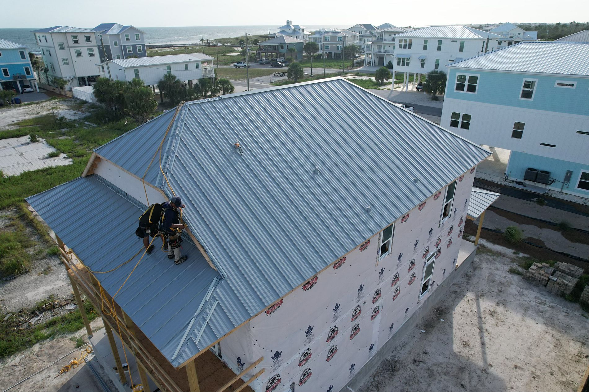 Certified Roofing Solutions contractors installing a standing seam metal roof on a beachfront home in Mexico Beach, FL.