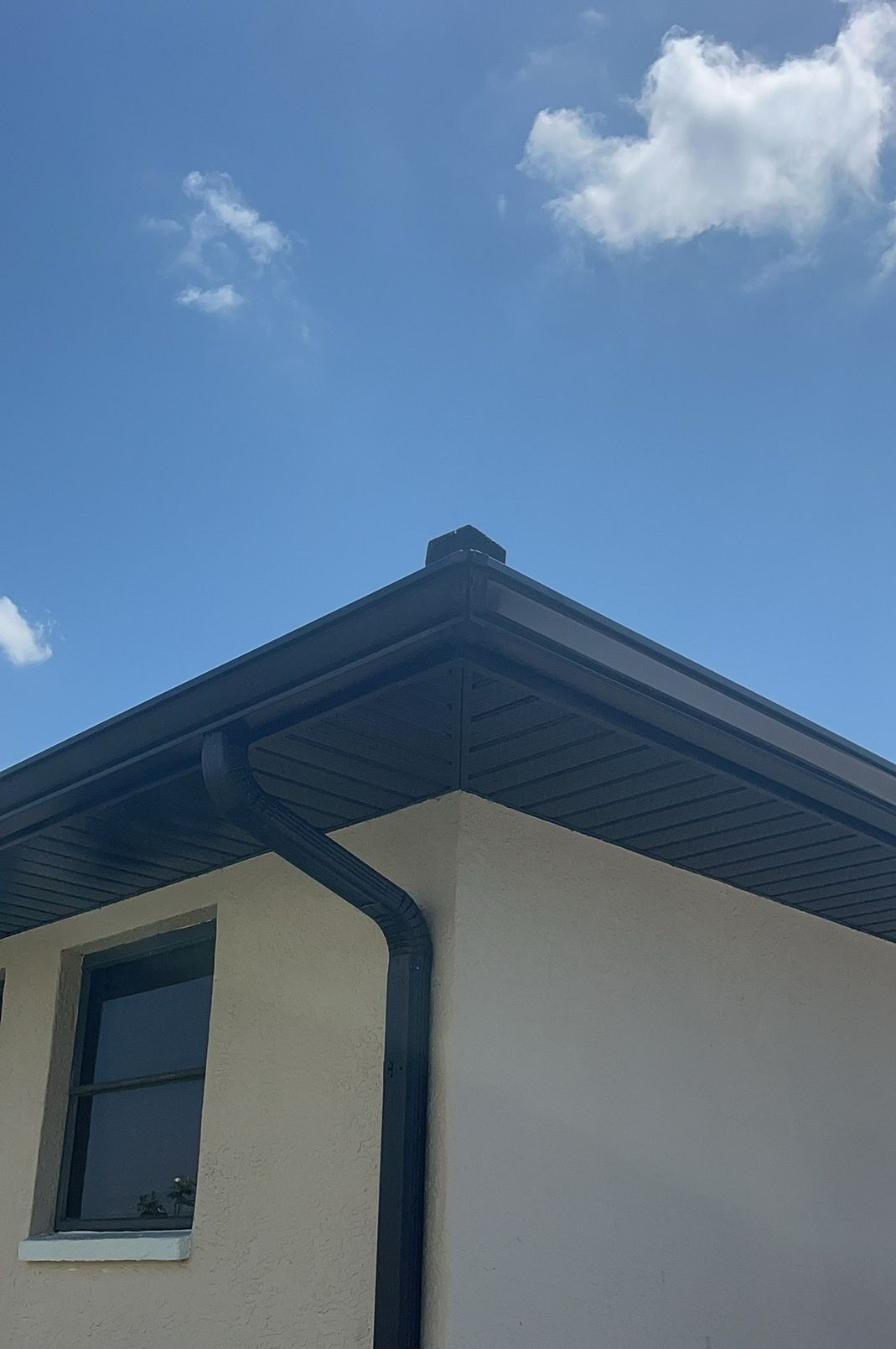 Black 6-inch K-style gutter and downspout installed on a property in Wauchula, Florida