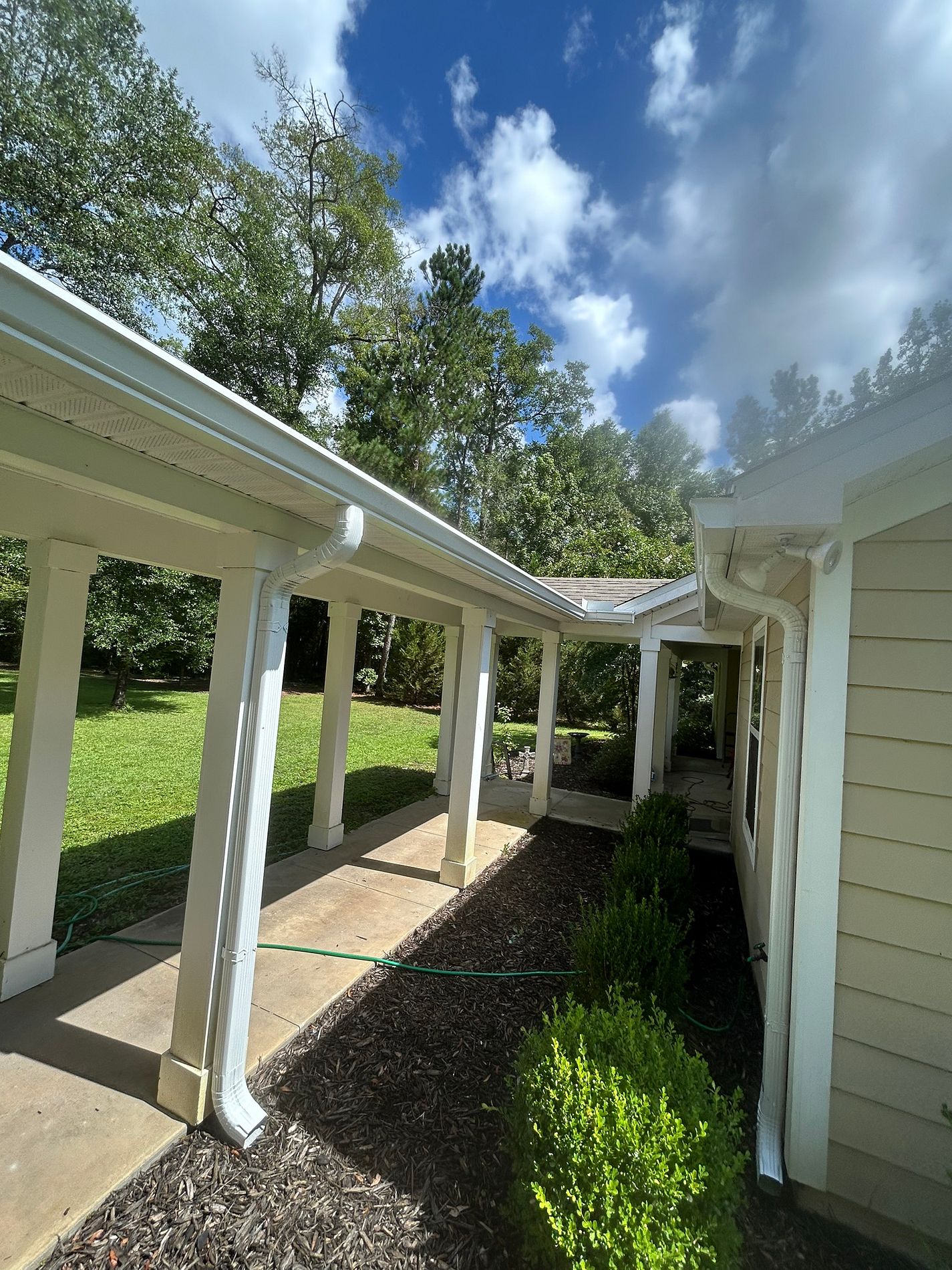 White 6-inch K-style gutters and downspouts installed on a home in Crawfordville, Florida