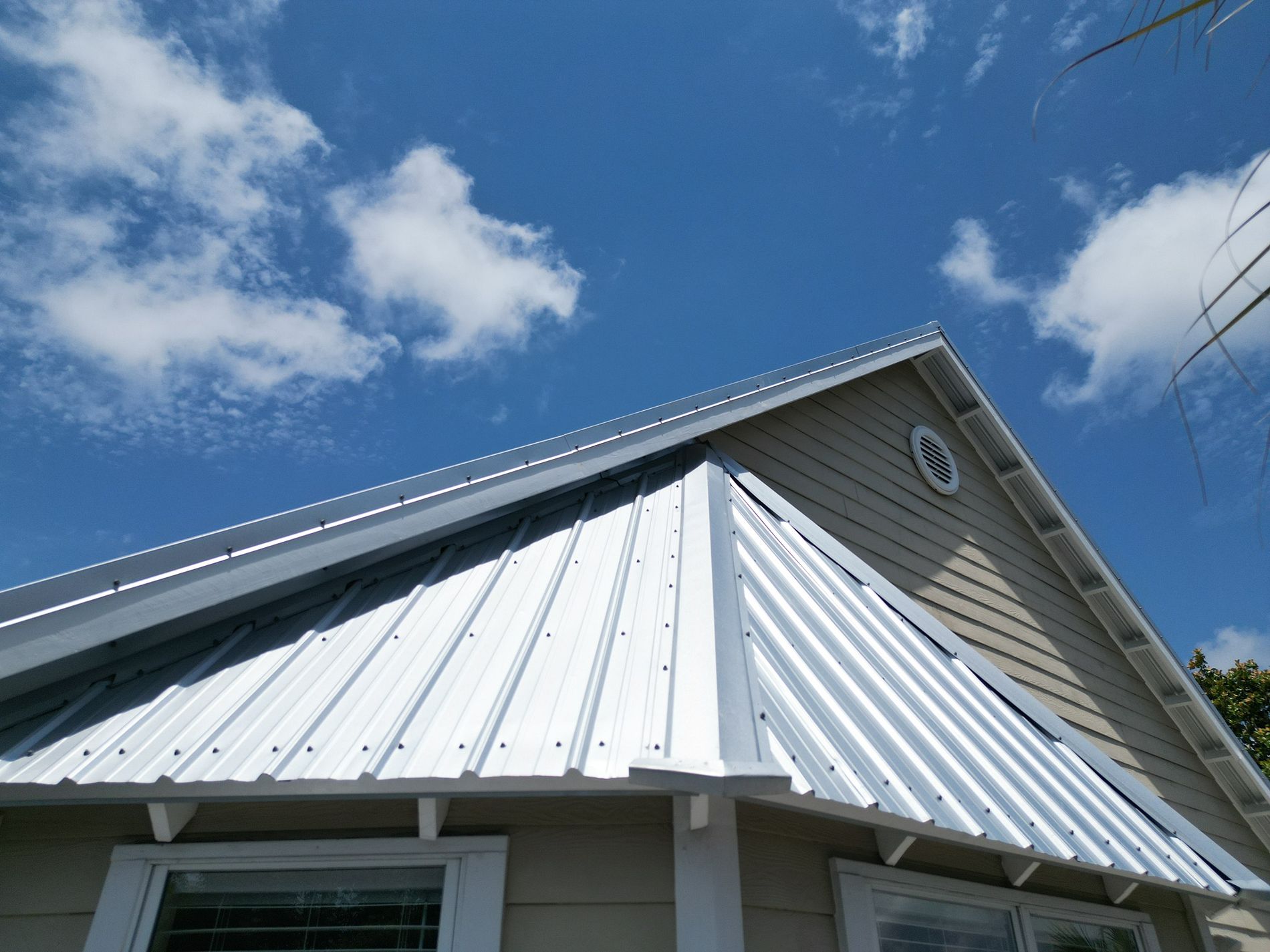 White exposed-fastener metal roof installed on a residential home in Hosford, Florida