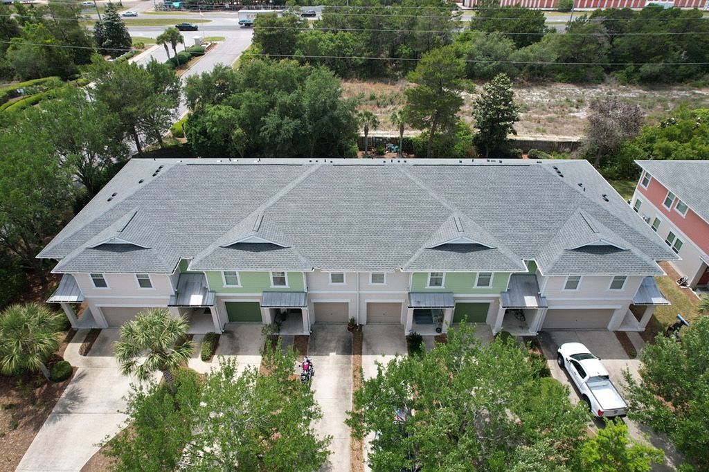 Front aerial view of a multi-family townhouse complex featuring a new GAF Timberline HDZ shingle roof in Panama City Beach, FL.