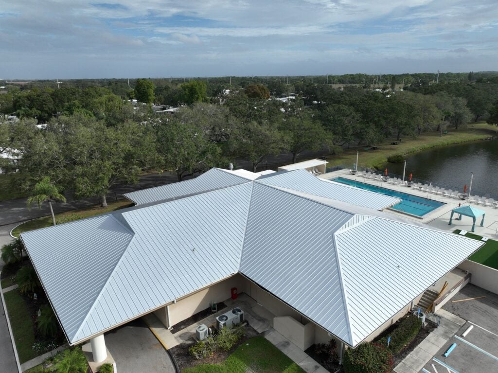 Wide corner aerial photo of a silver 24-gauge standing seam metal roof on a Sarasota commercial facility.