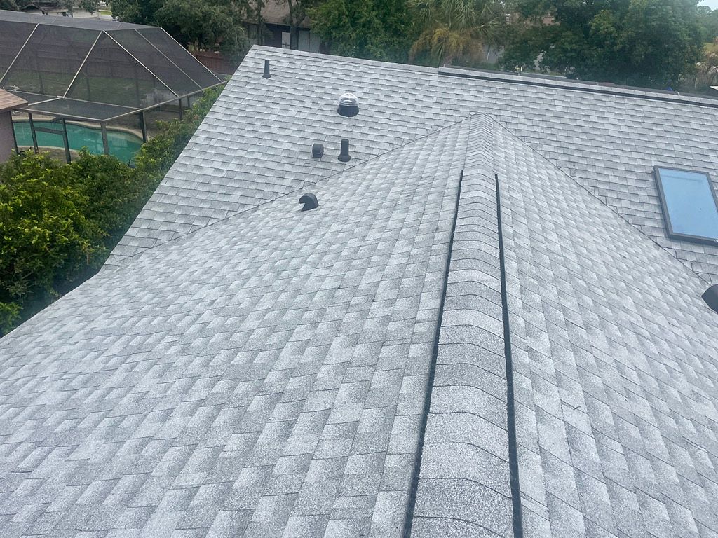 Elevated view of a completed Pewter Gray GAF Timberline HDZ architectural shingle roofing system on a residential property in Spring Hill, Florida.